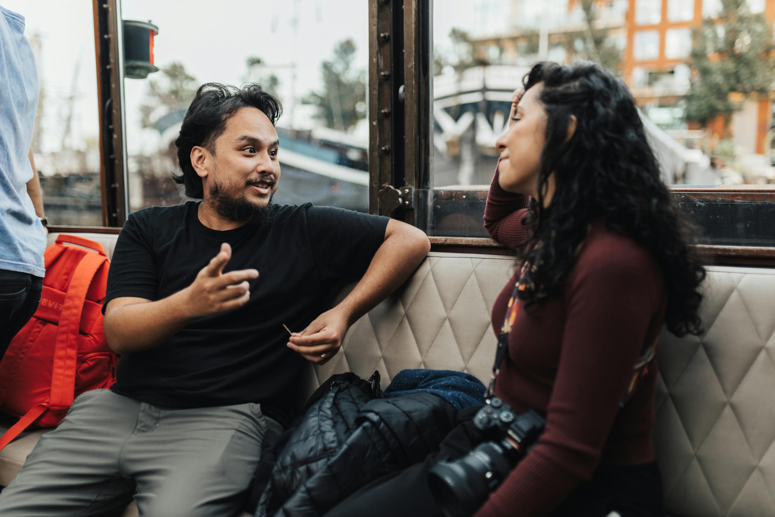 Two friends engaging in a relaxed conversation indoors, surrounded by modern decor.
