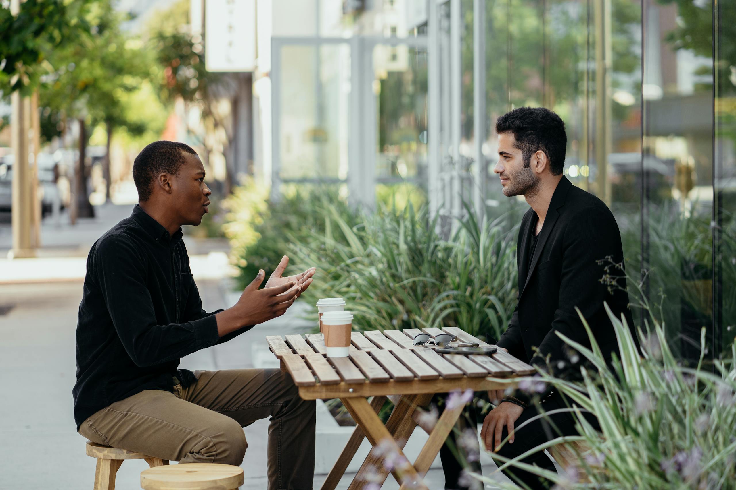 Two men having a business meeting at an outdoor café setting.