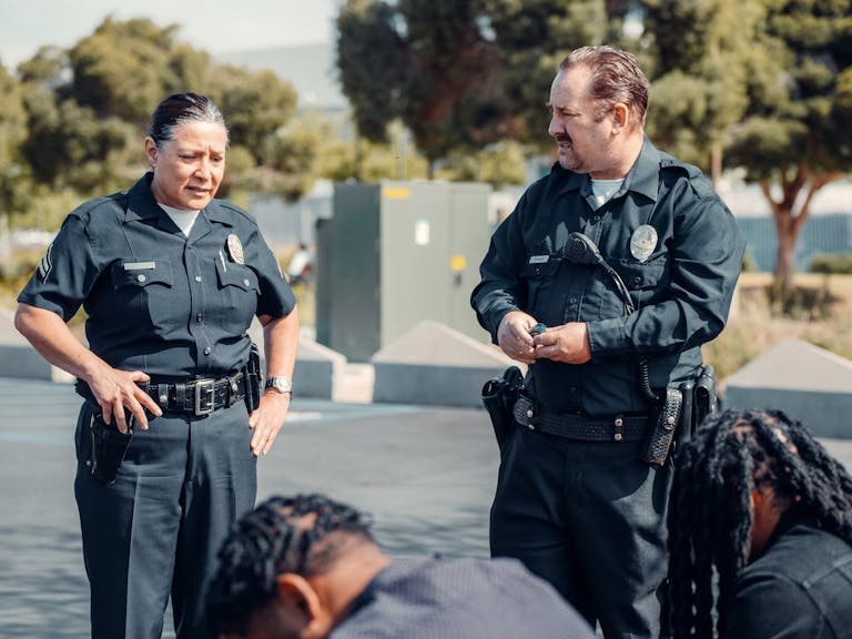 Two police officers interact with citizens during a community patrol outdoors.
