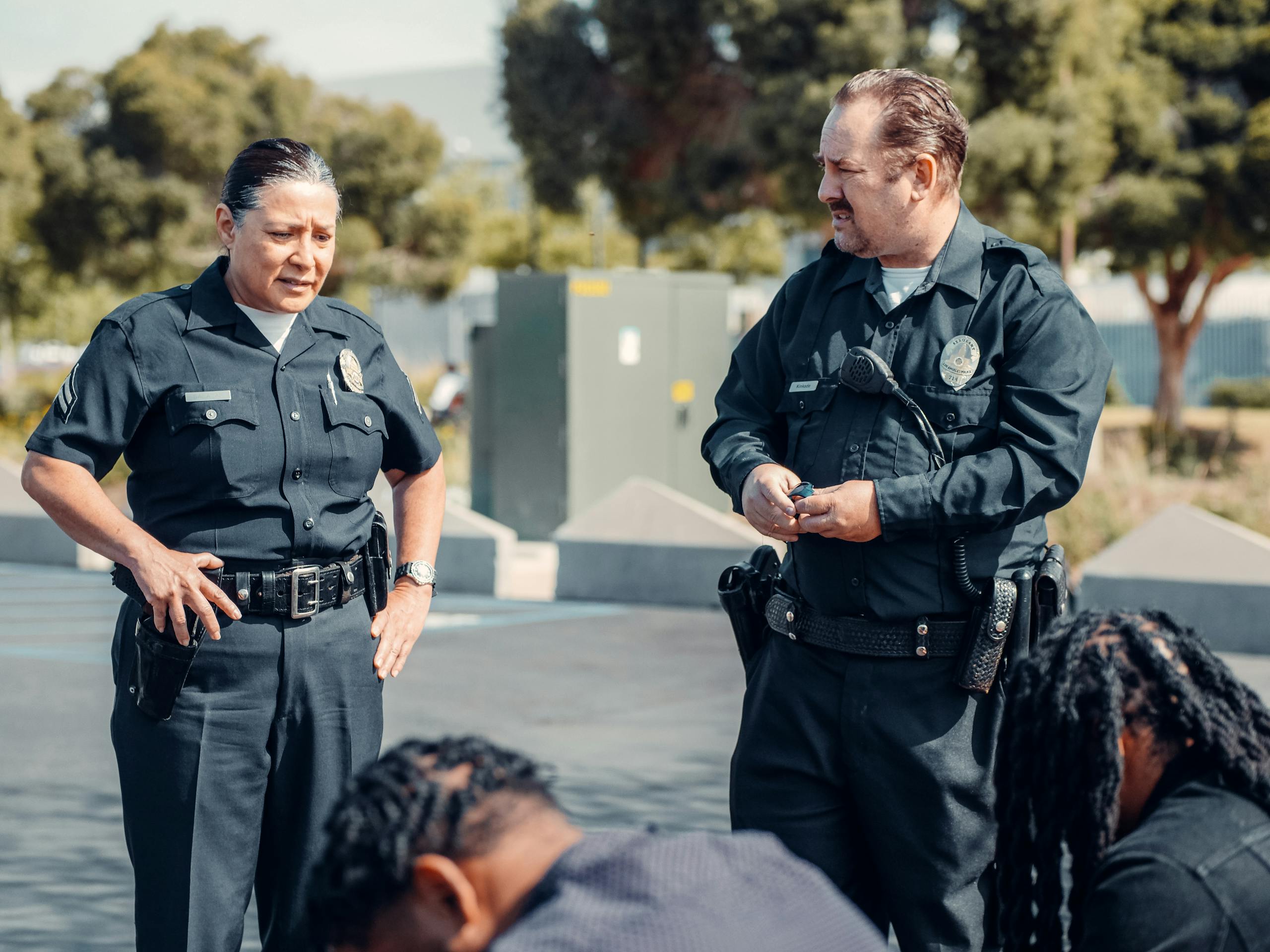 Two police officers interact with citizens during a community patrol outdoors.
