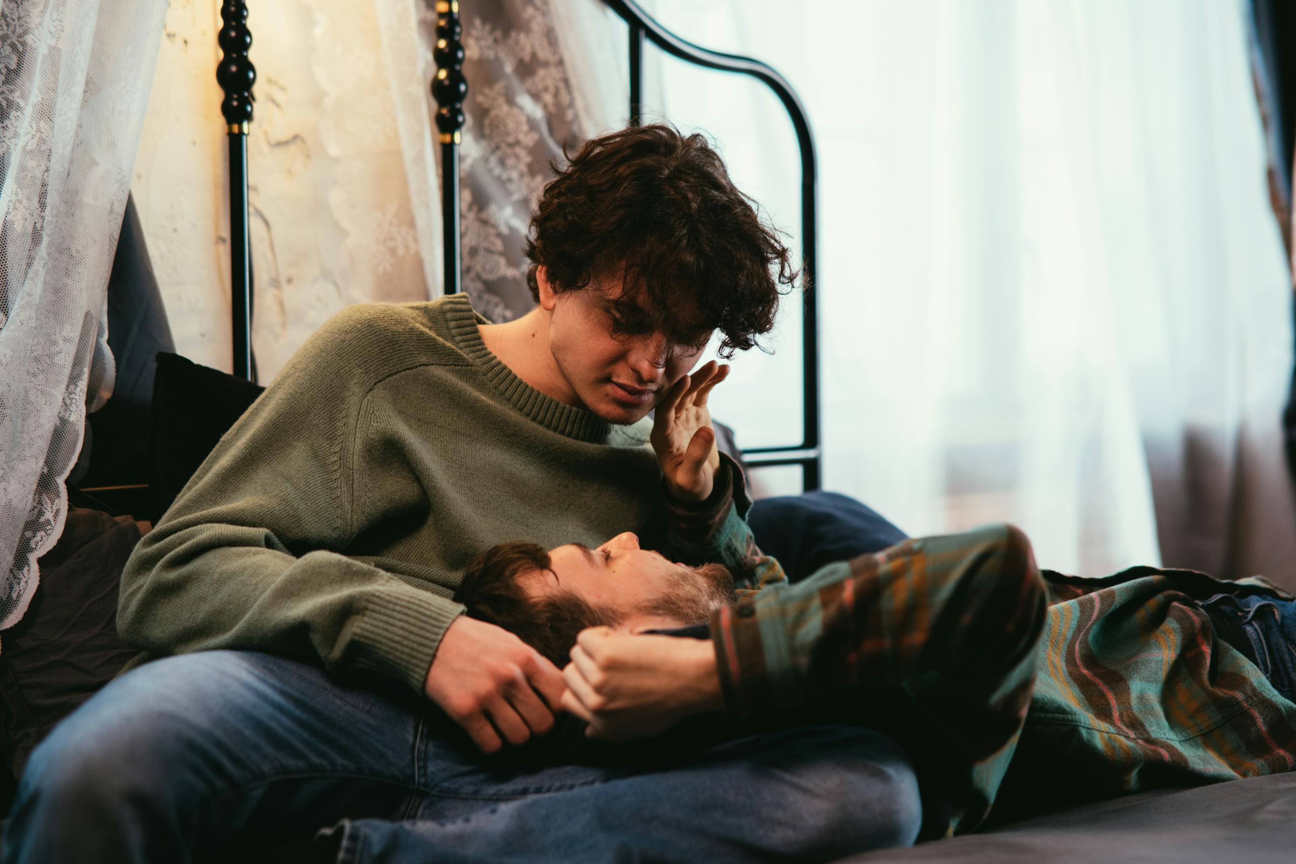 Two young adults sharing a tender moment indoors, symbolizing love and affection.