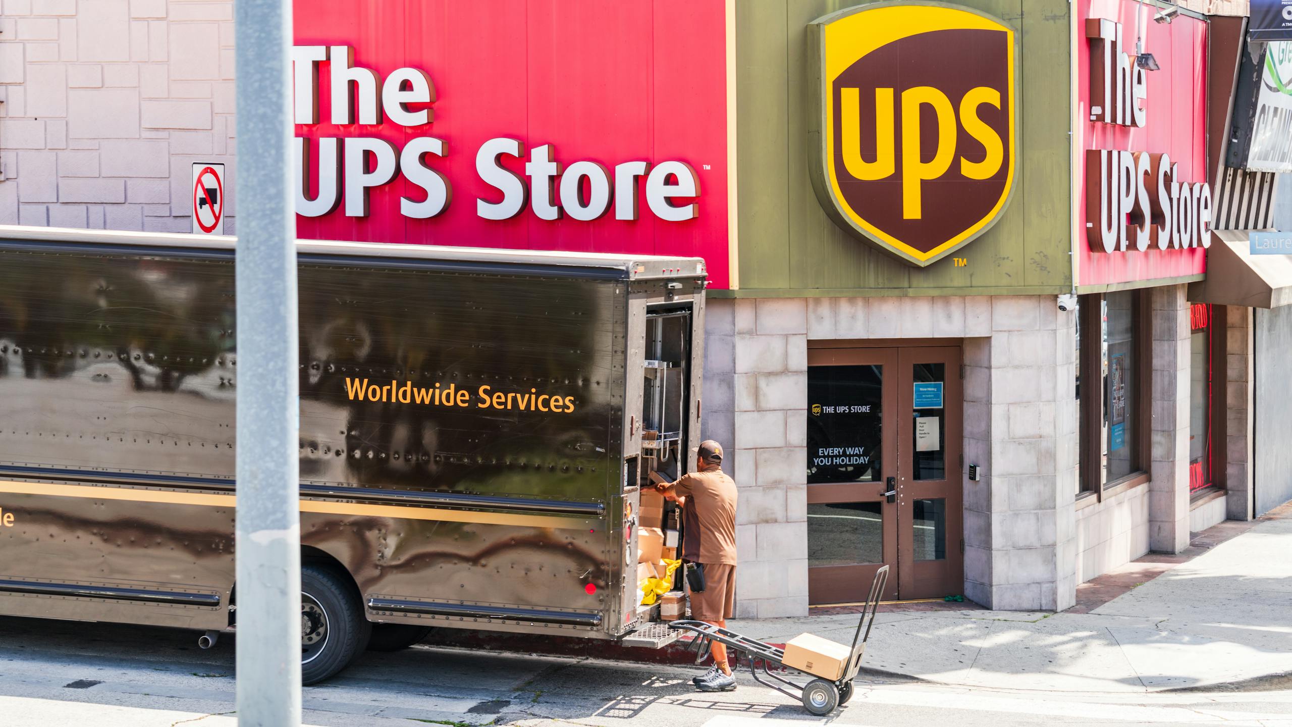 UPS delivery person unloading packages outside a UPS Store in Los Angeles, California.