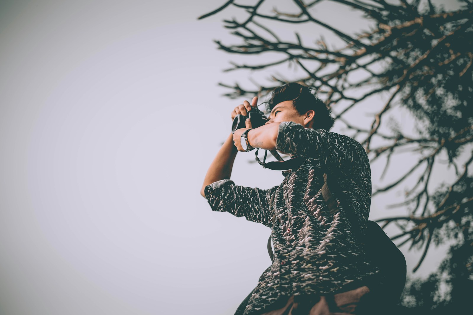 man taking photo near tree