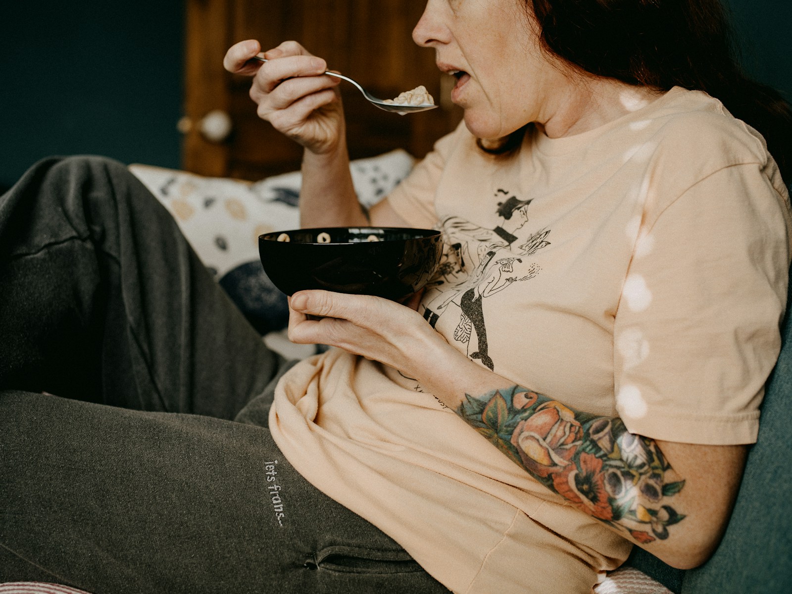 woman in white floral long sleeve shirt holding black ceramic mug