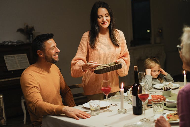 Warm family dinner with candles and wine, perfect for intimate home gatherings.