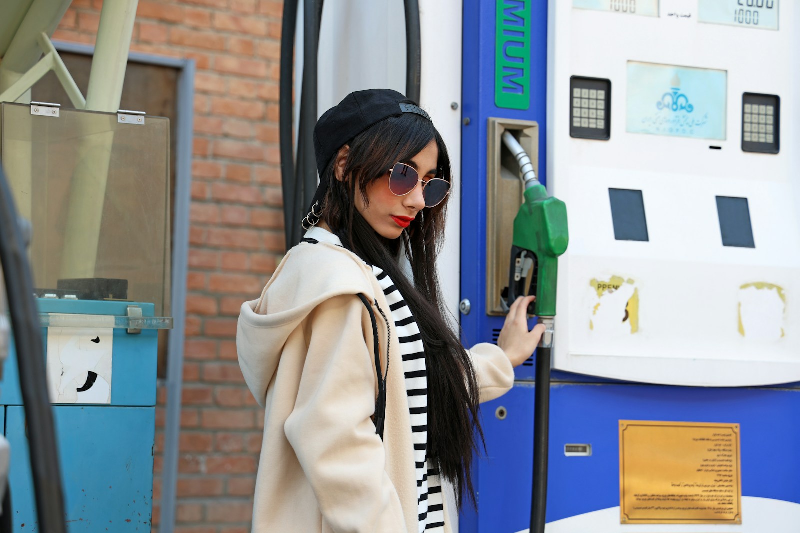 Woman holding gas pump at station