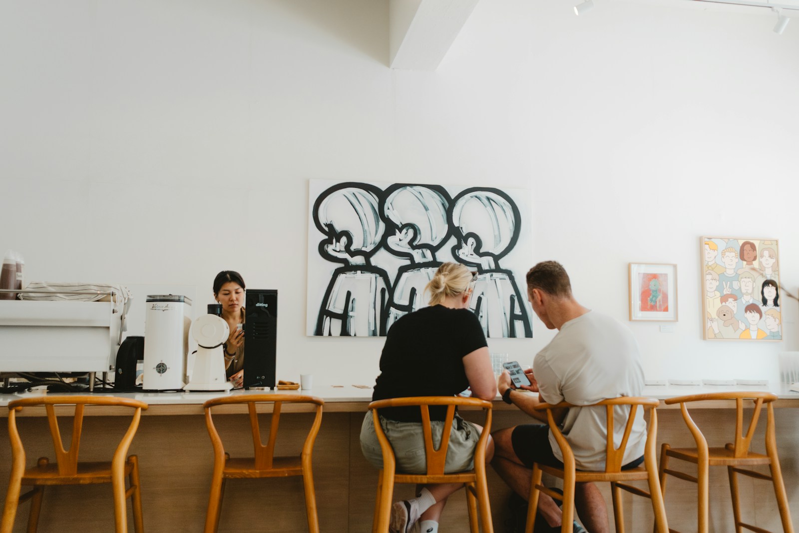 People sit at a counter in a cafe.