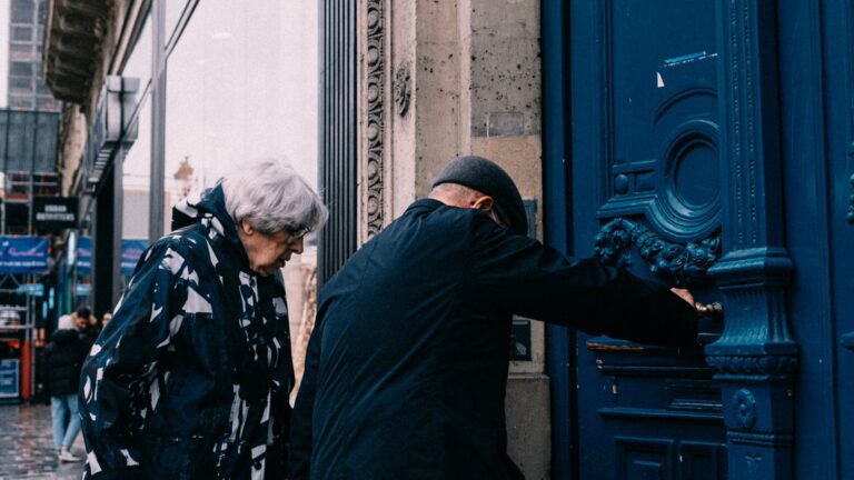 a couple of people standing next to a blue door