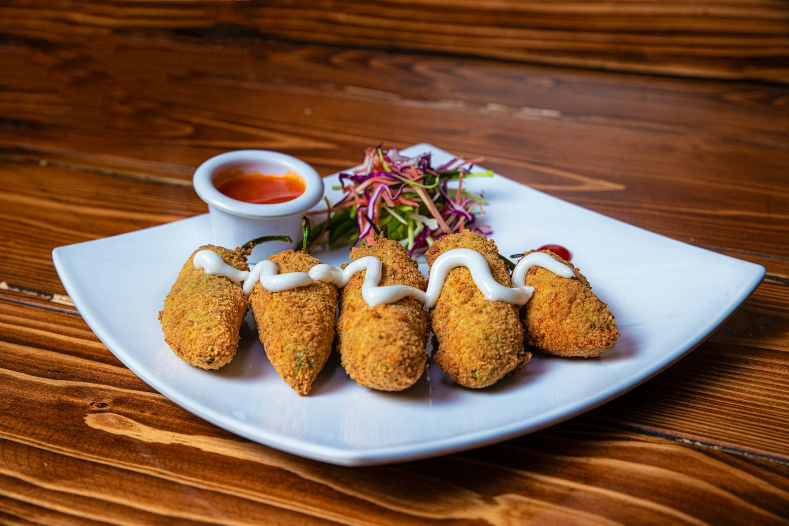 Crispy breaded jalapeño peppers served with a tangy dipping sauce for a flavorful appetizer.