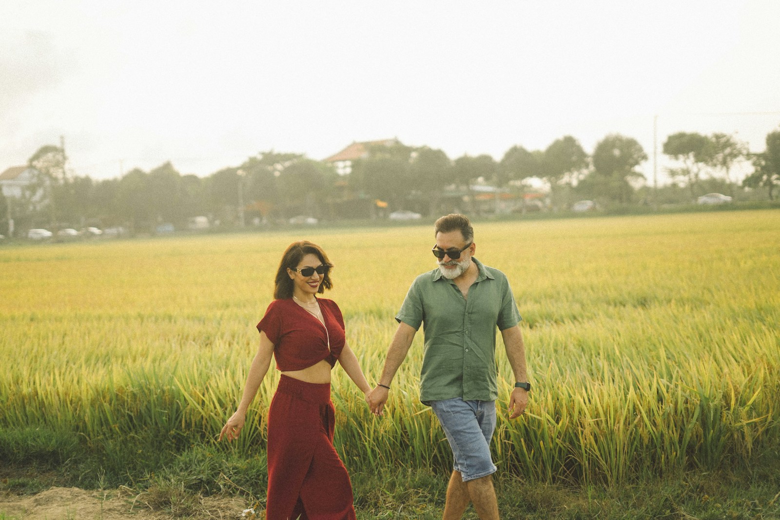 Couple walking hand in hand through a field