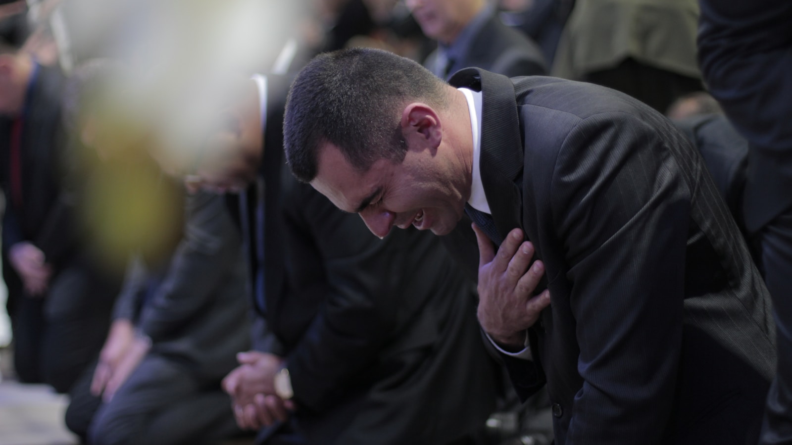 man bowing while crying