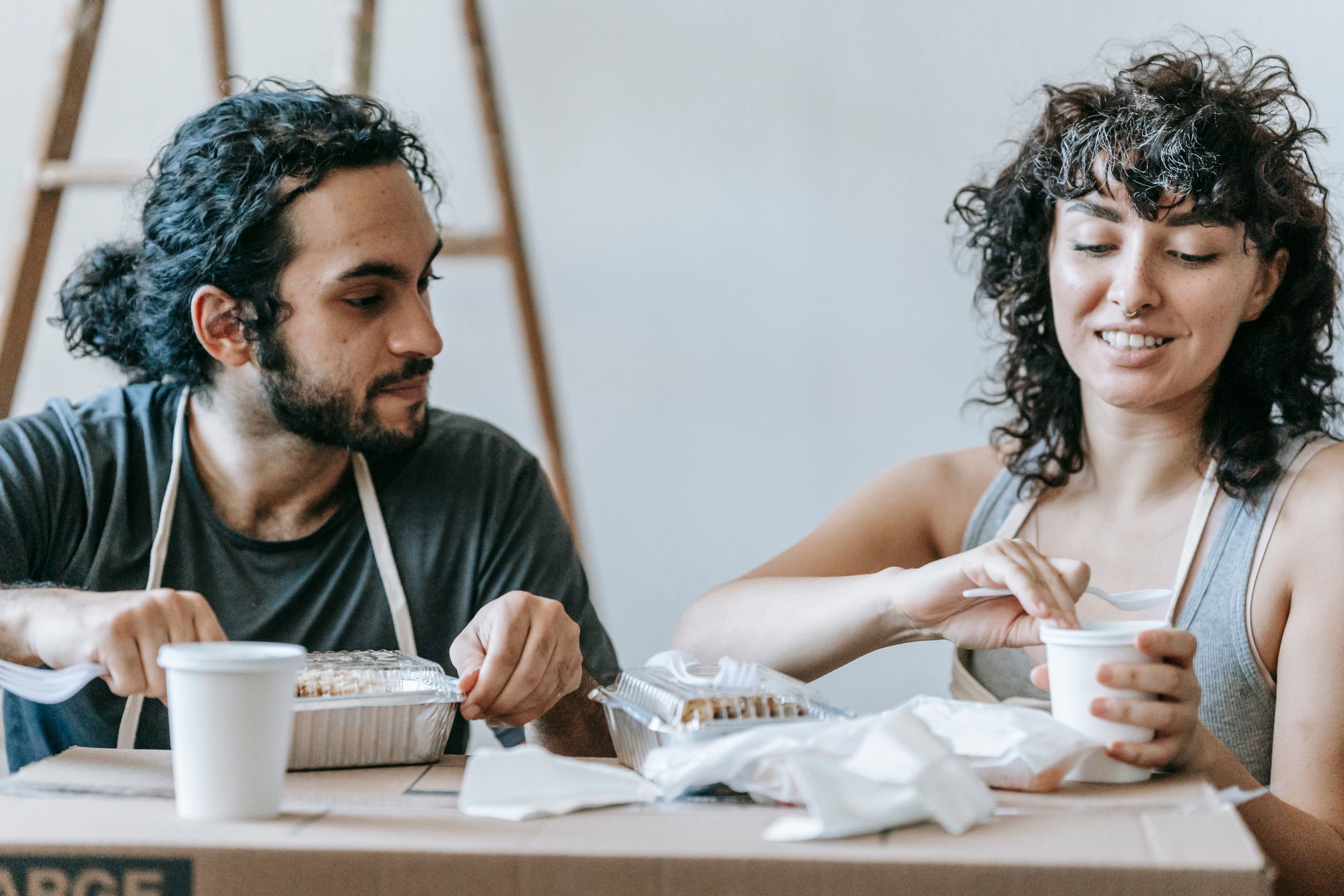 A couple enjoys a casual meal on moving day, highlighting togetherness during transition.