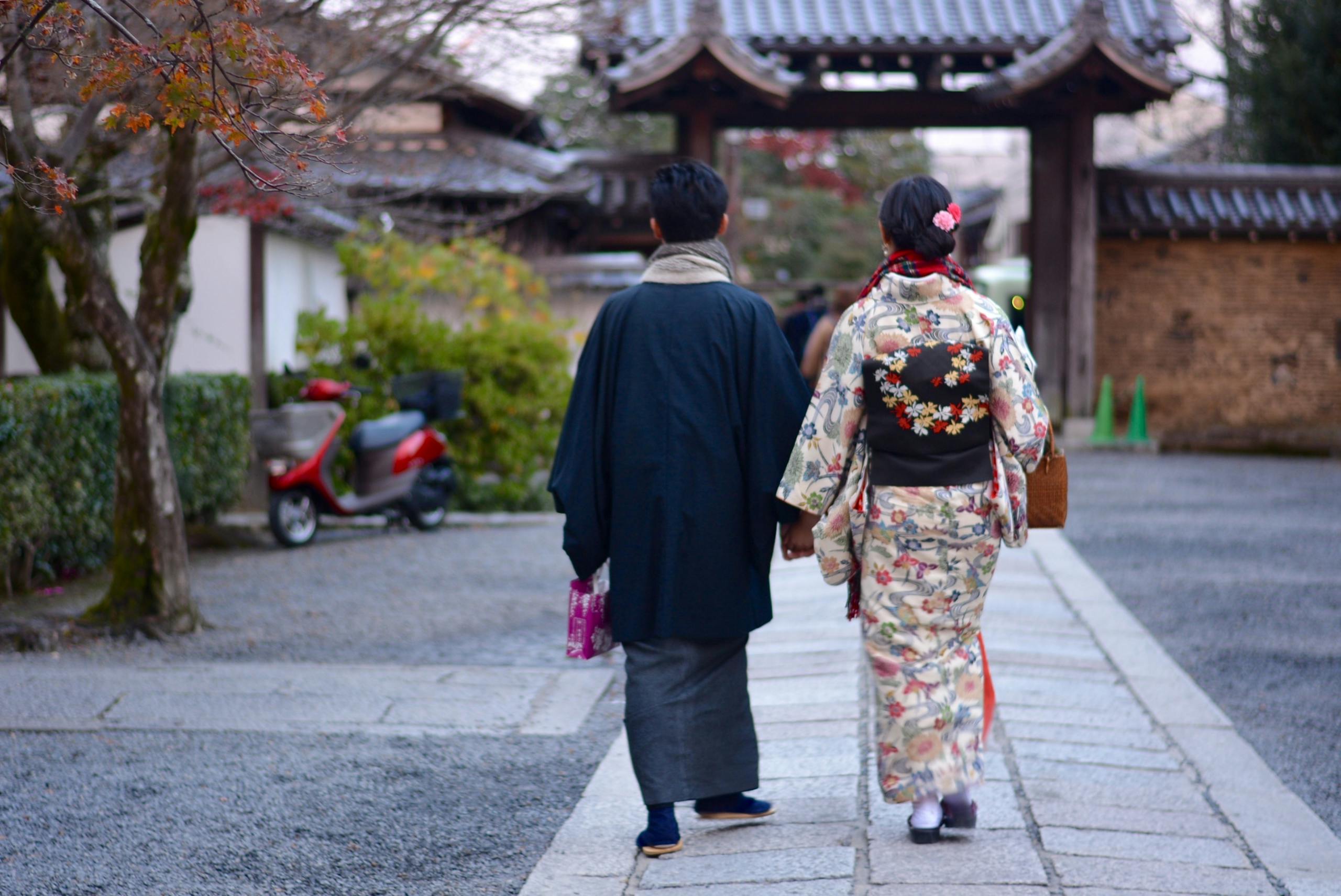 A couple strolling in traditional kimonos through a serene Japanese street.