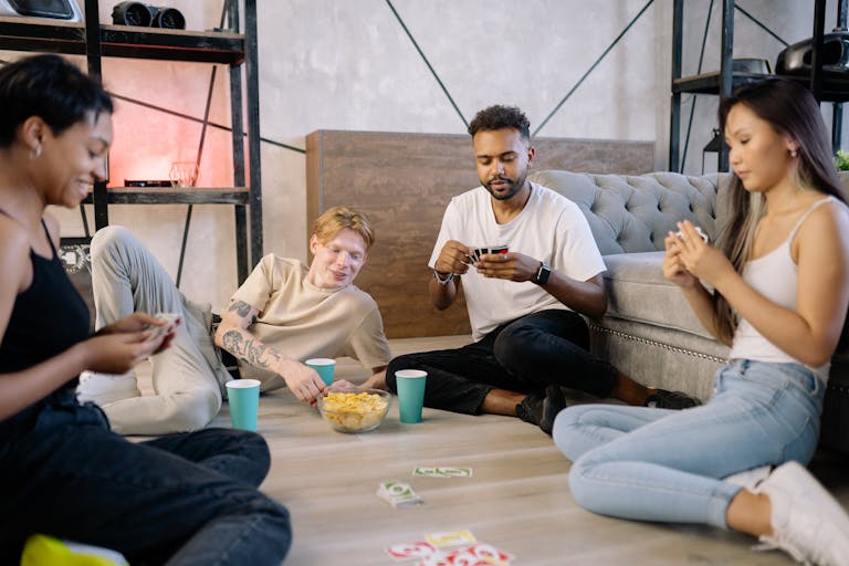 A diverse group of friends enjoying a card game indoors, creating a relaxed and fun atmosphere.