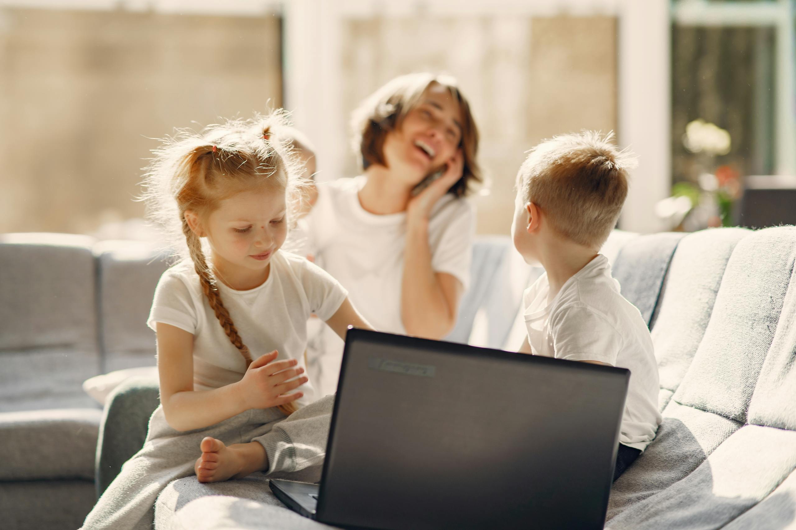 A family enjoying bonding time indoors using a laptop, filled with happiness and togetherness.