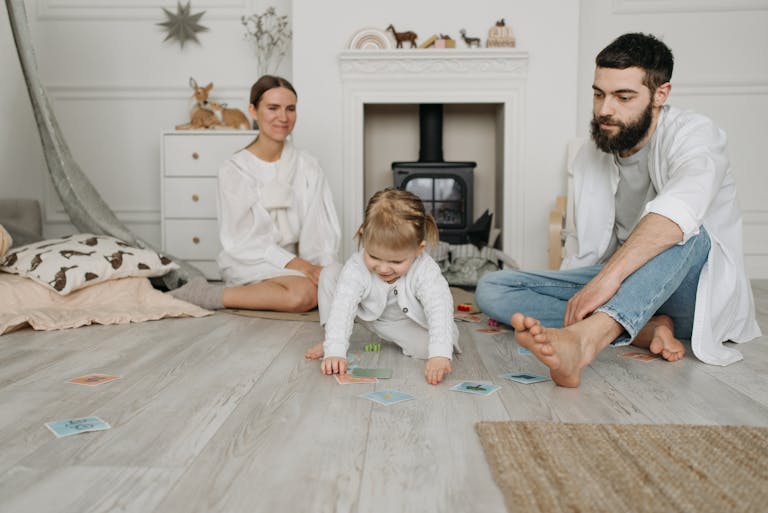 A family enjoying quality time together indoors with their child playing on the floor.