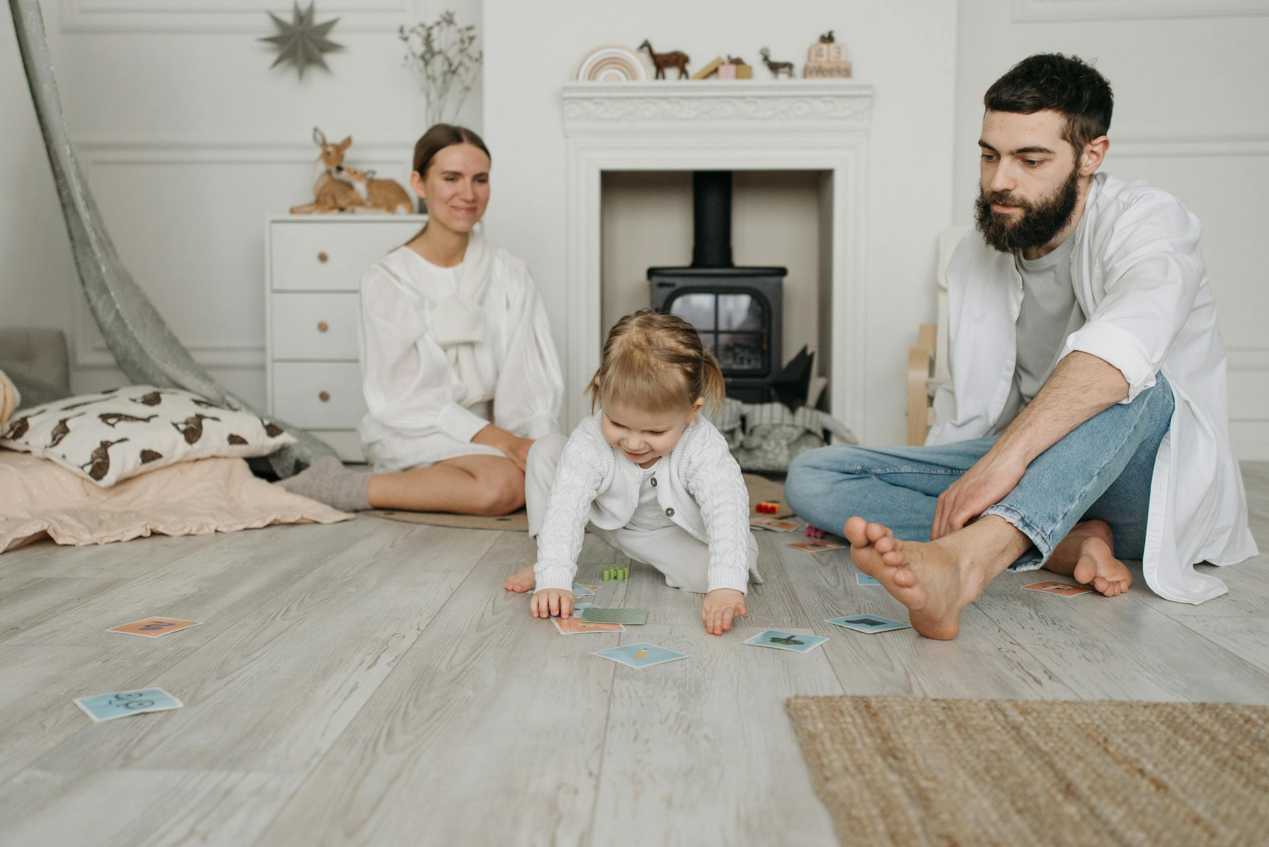 A family enjoying quality time together indoors with their child playing on the floor.