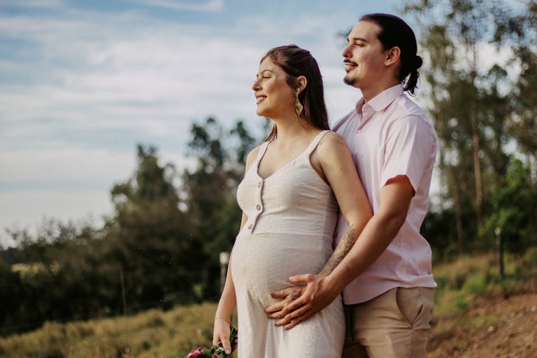 A happy pregnant couple enjoying a loving moment outdoors in Londrina, Brazil.