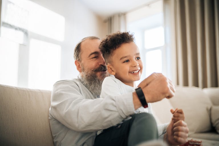 A heartwarming moment of a grandfather and grandson enjoying time together indoors.