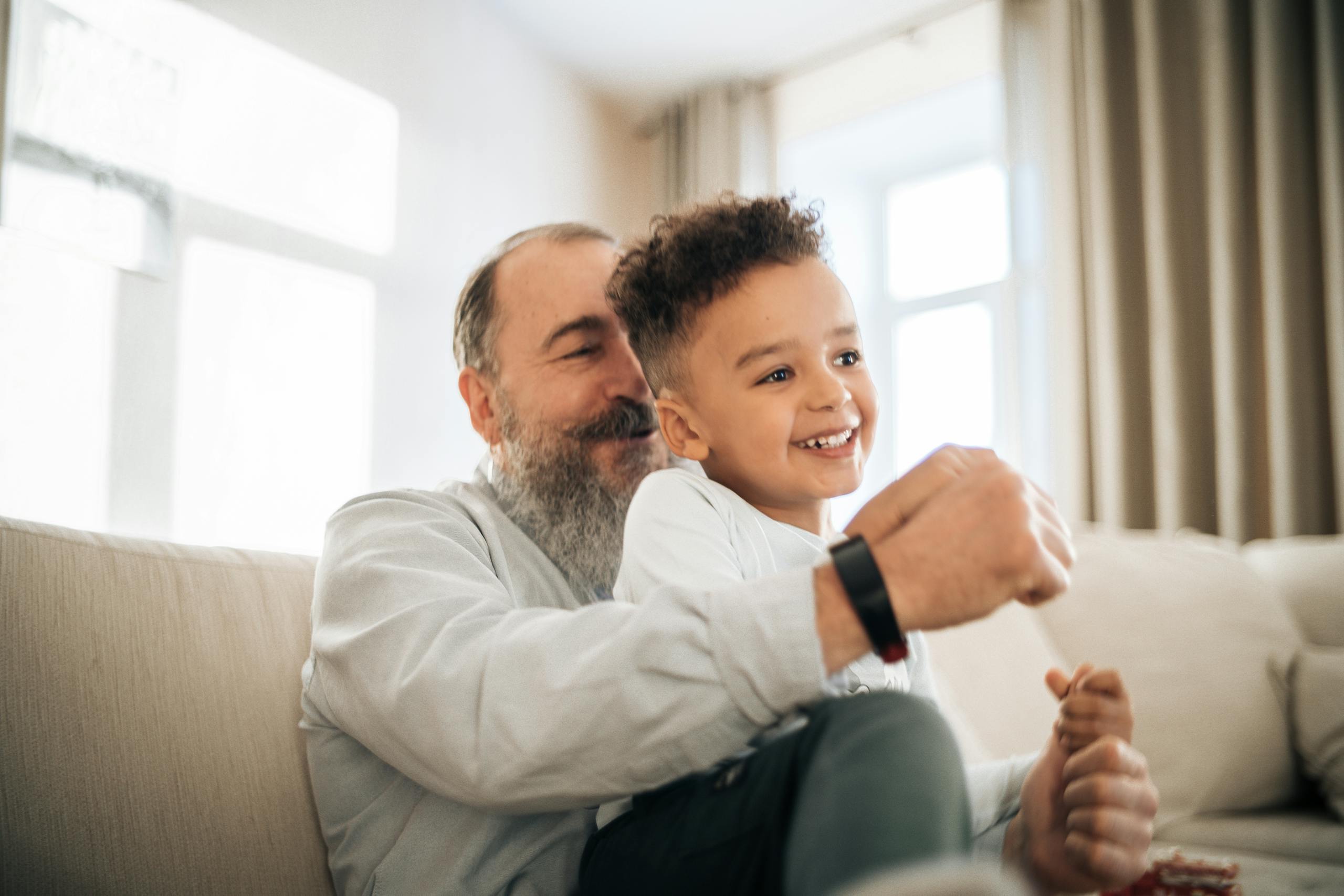 A heartwarming moment of a grandfather and grandson enjoying time together indoors.