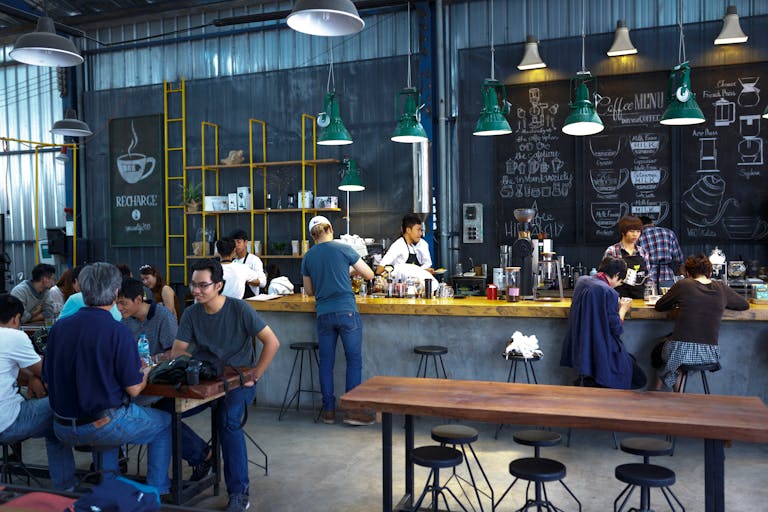 A lively coffee shop with patrons and baristas engaging in a vibrant atmosphere.