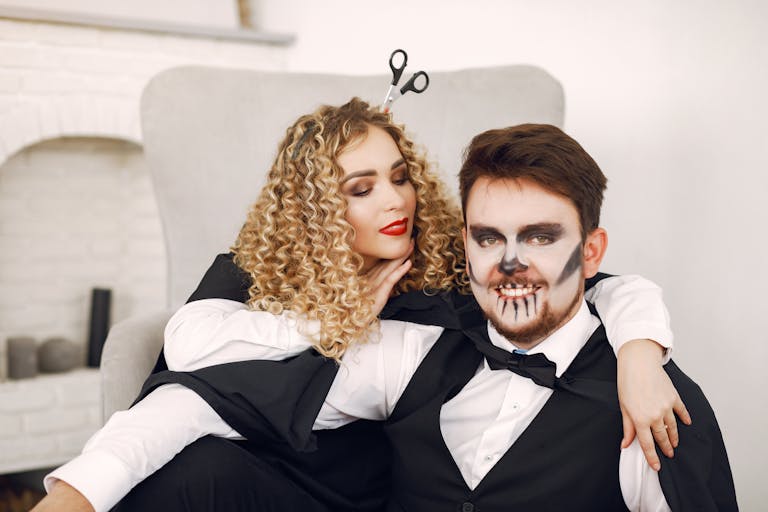 A loving couple dressed in creative Halloween costumes inside a cozy room.