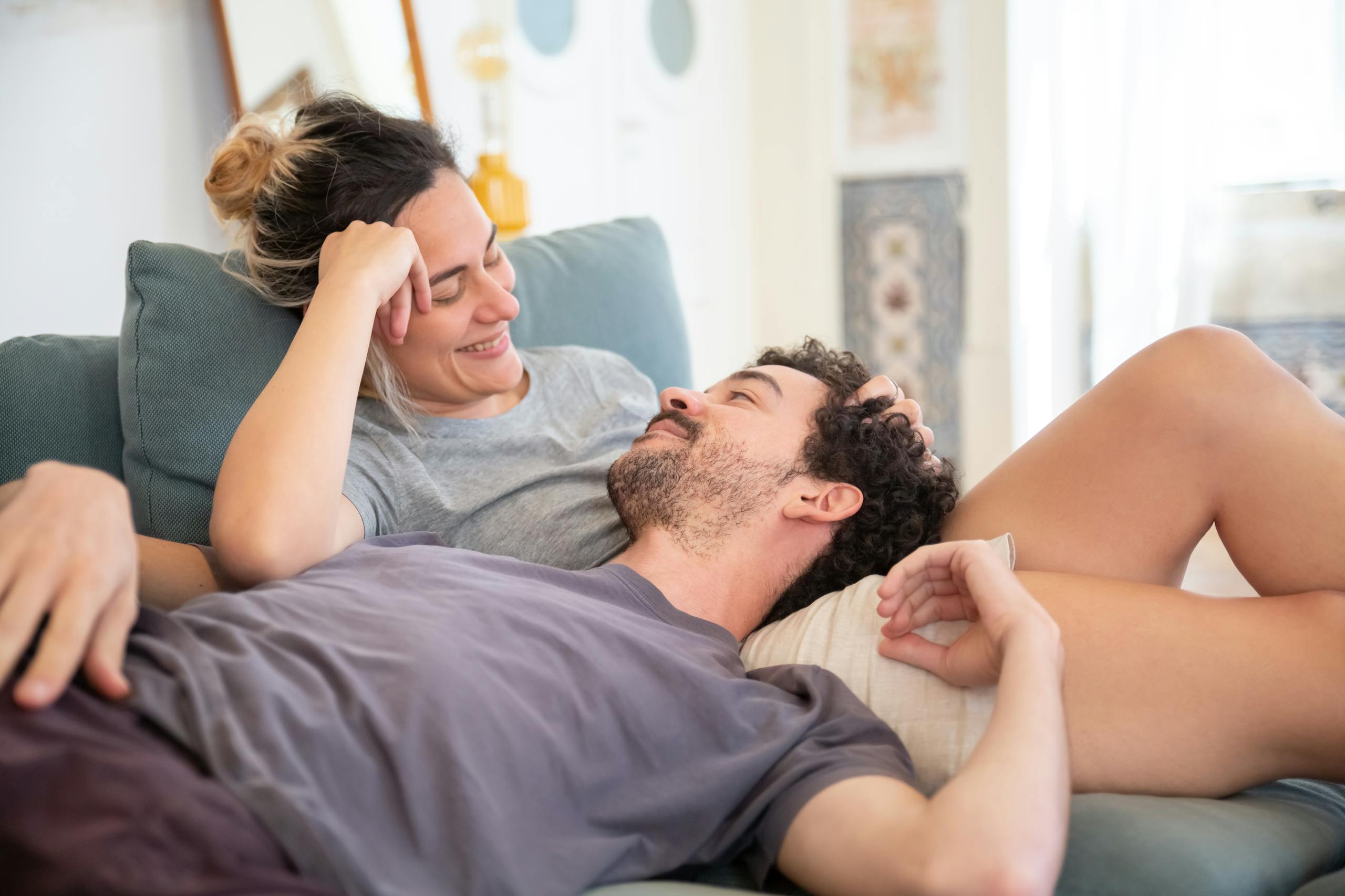 A loving couple enjoys a relaxed moment at home, showcasing affection and comfort.