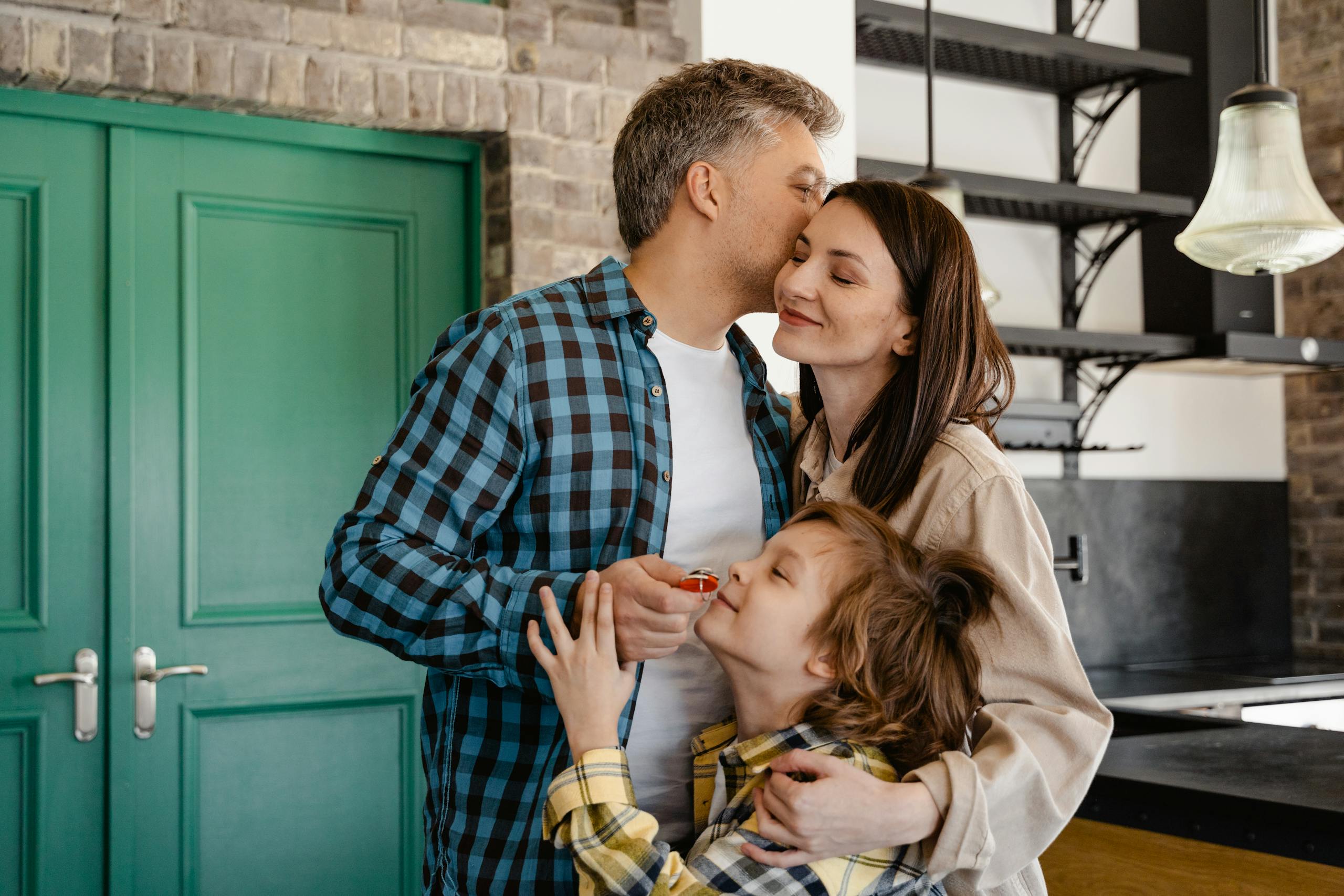 A loving family shares a group hug in their modern kitchen, showcasing warmth and togetherness.