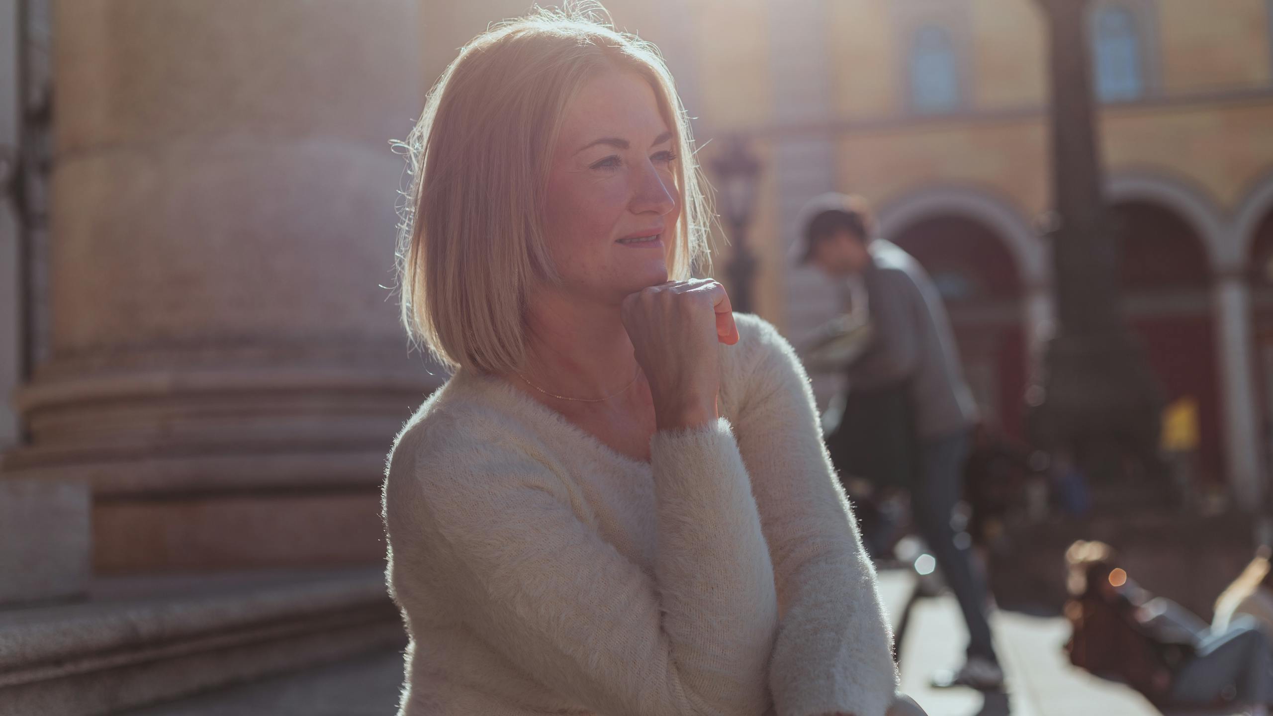 A middle-aged woman enjoying a sunny day outdoors in Munich, Germany.