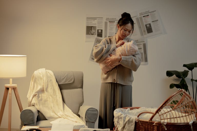 A mother lovingly cradles her newborn in a cozy living room, evoking warmth and care.