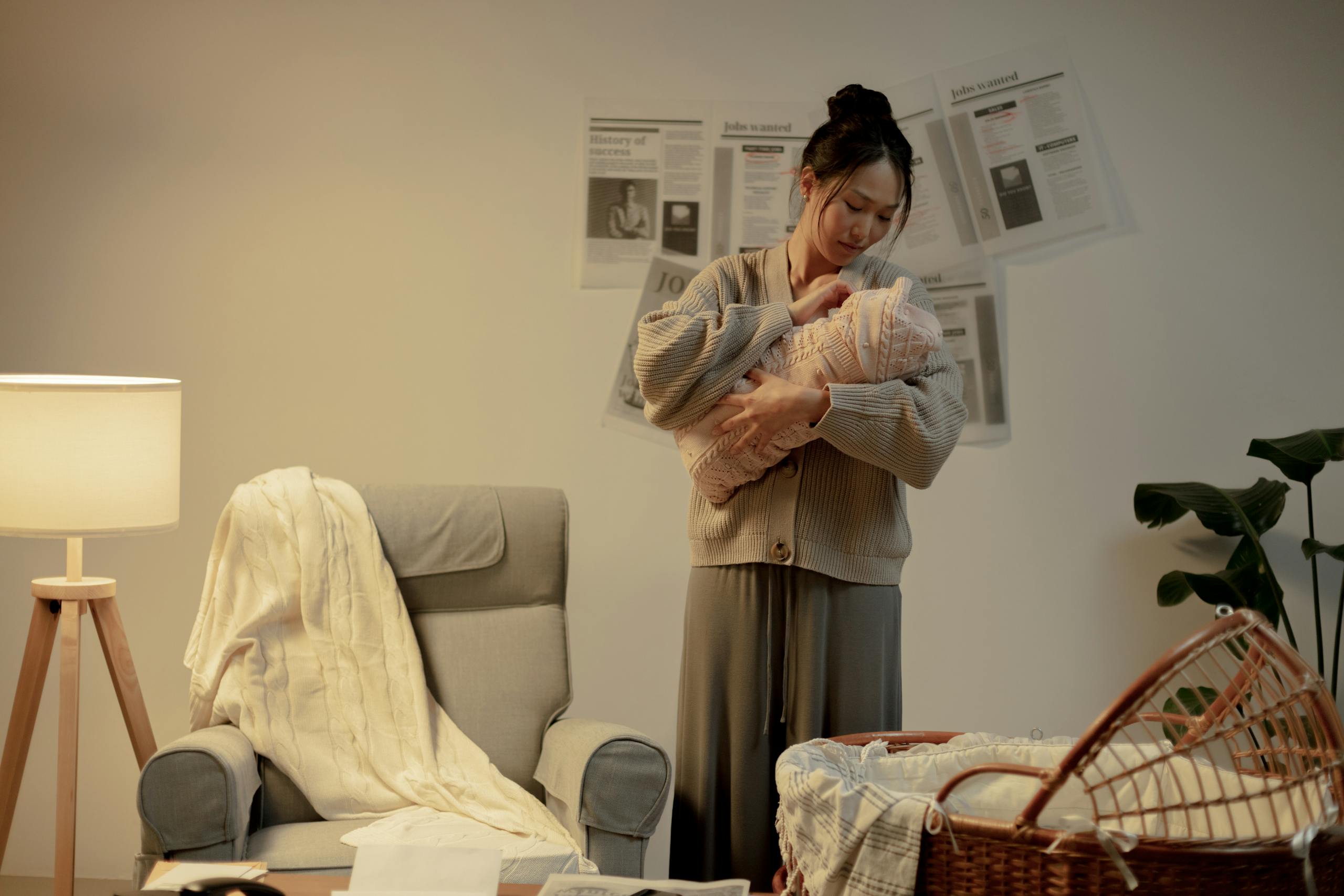 A mother lovingly cradles her newborn in a cozy living room, evoking warmth and care.