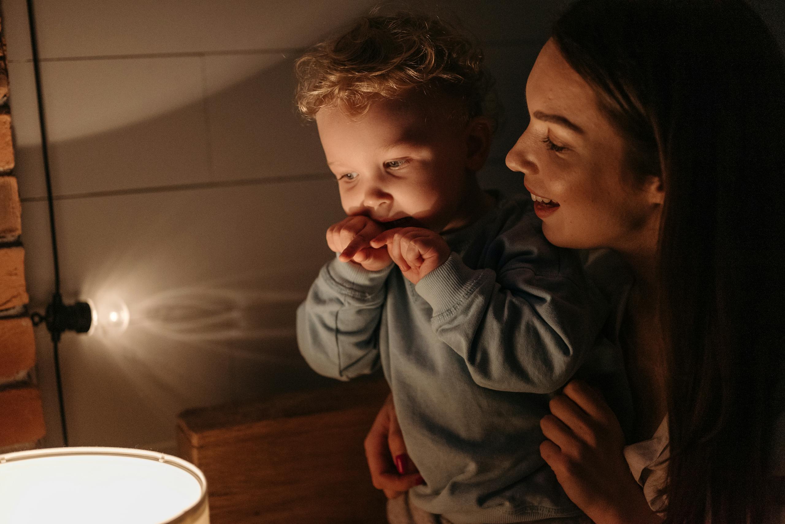 A warm scene of a mother and her son enjoying a quiet evening illuminated by gentle candlelight.