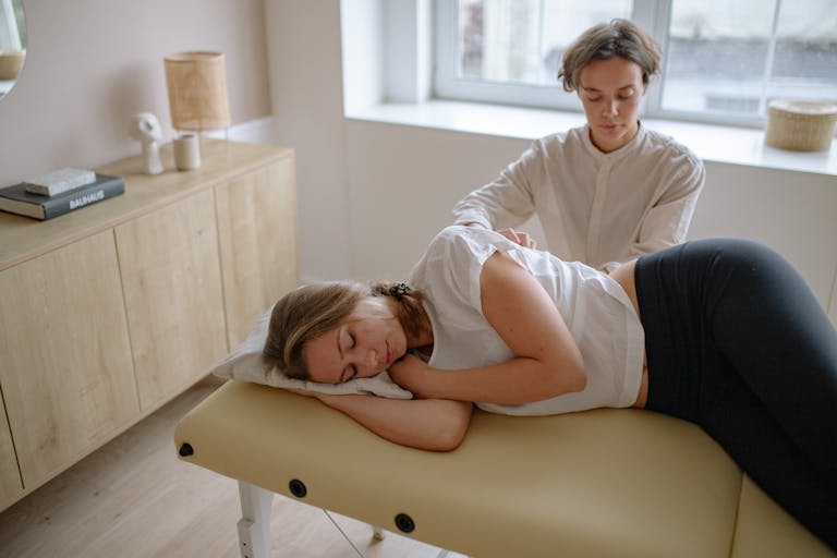 A woman receives a therapeutic massage from a specialist indoors.