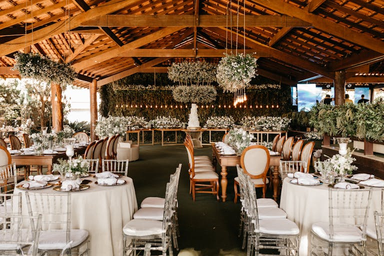 Beautifully arranged wedding reception under a wooden canopy featuring elegant decor and floral arrangements.
