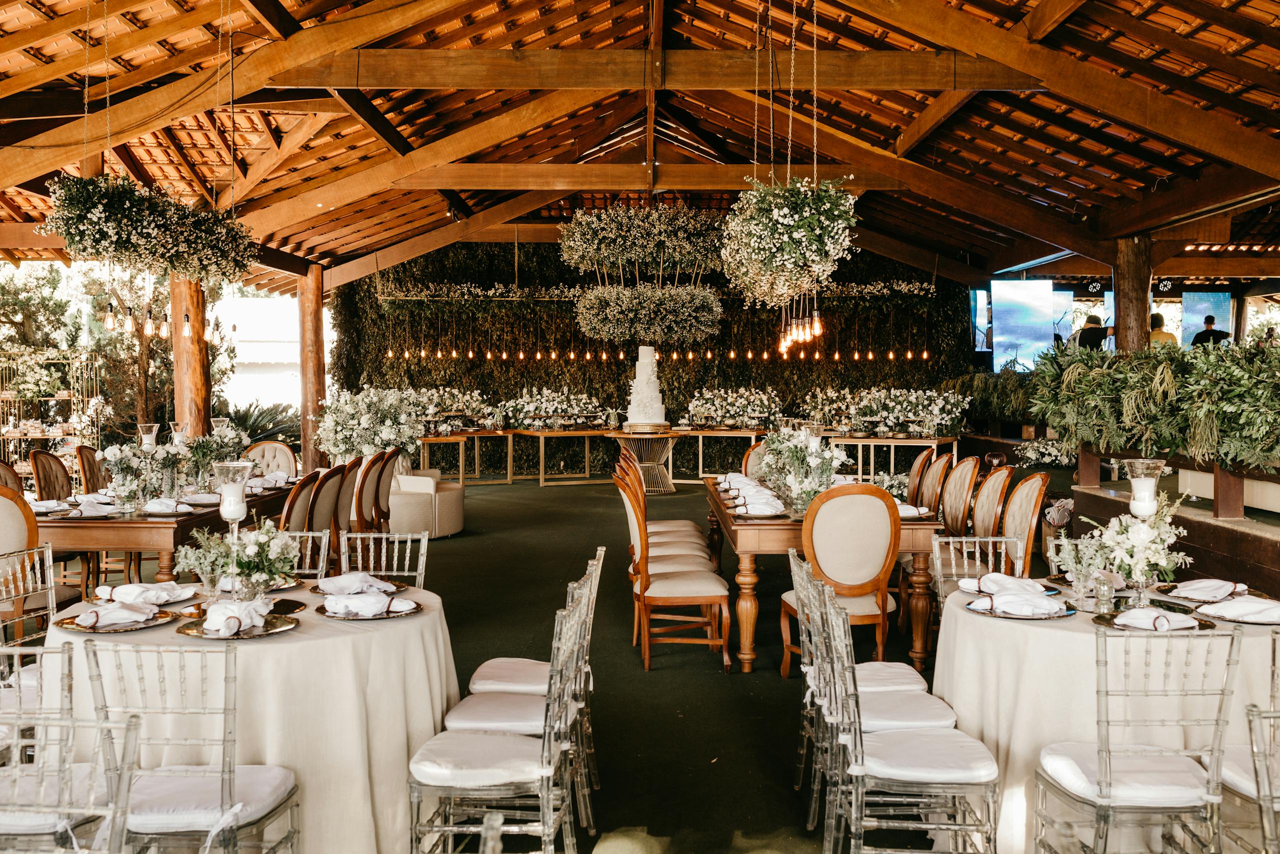 Beautifully arranged wedding reception under a wooden canopy featuring elegant decor and floral arrangements.
