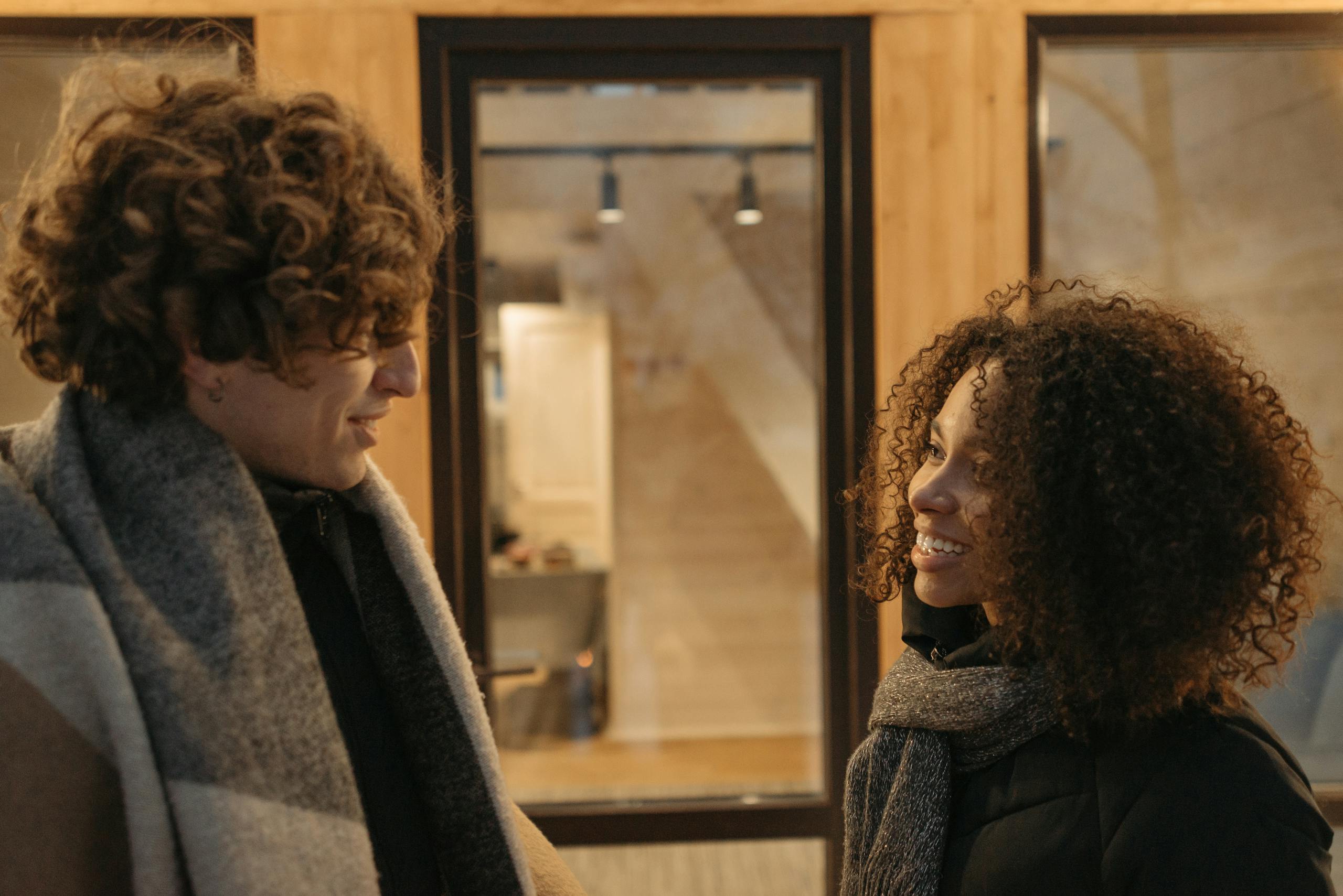 Casually dressed couple shares a joyful moment inside a cozy setting.