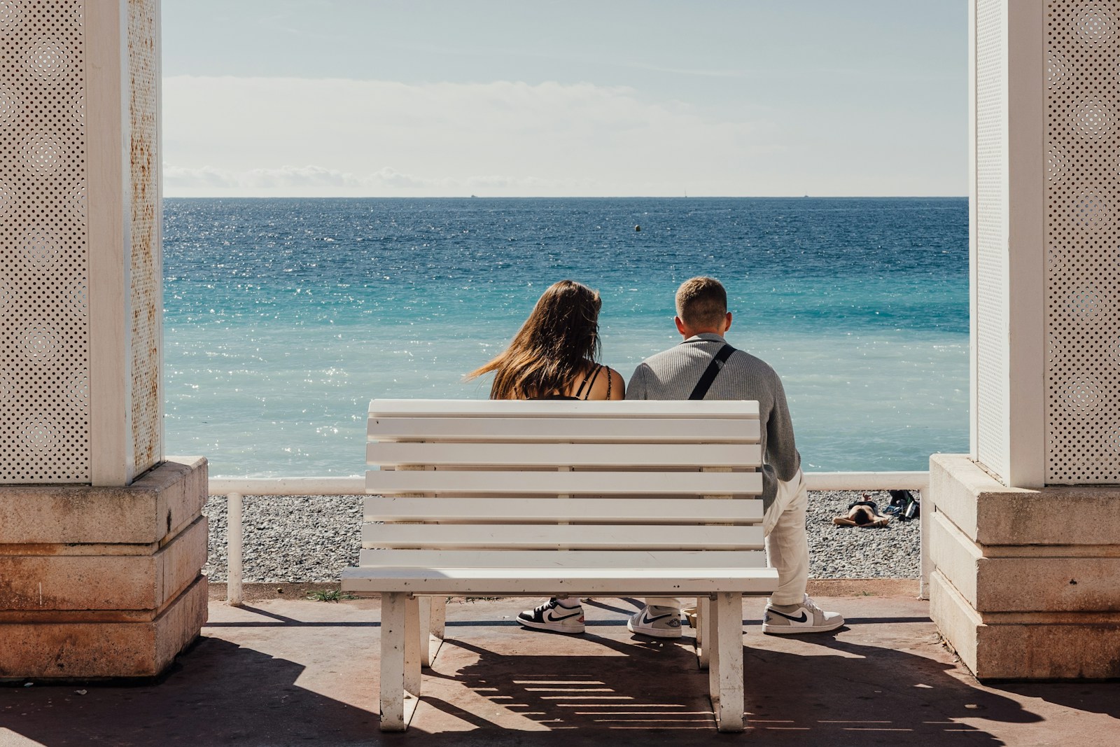 Couple sitting on a bench overlooking the ocean