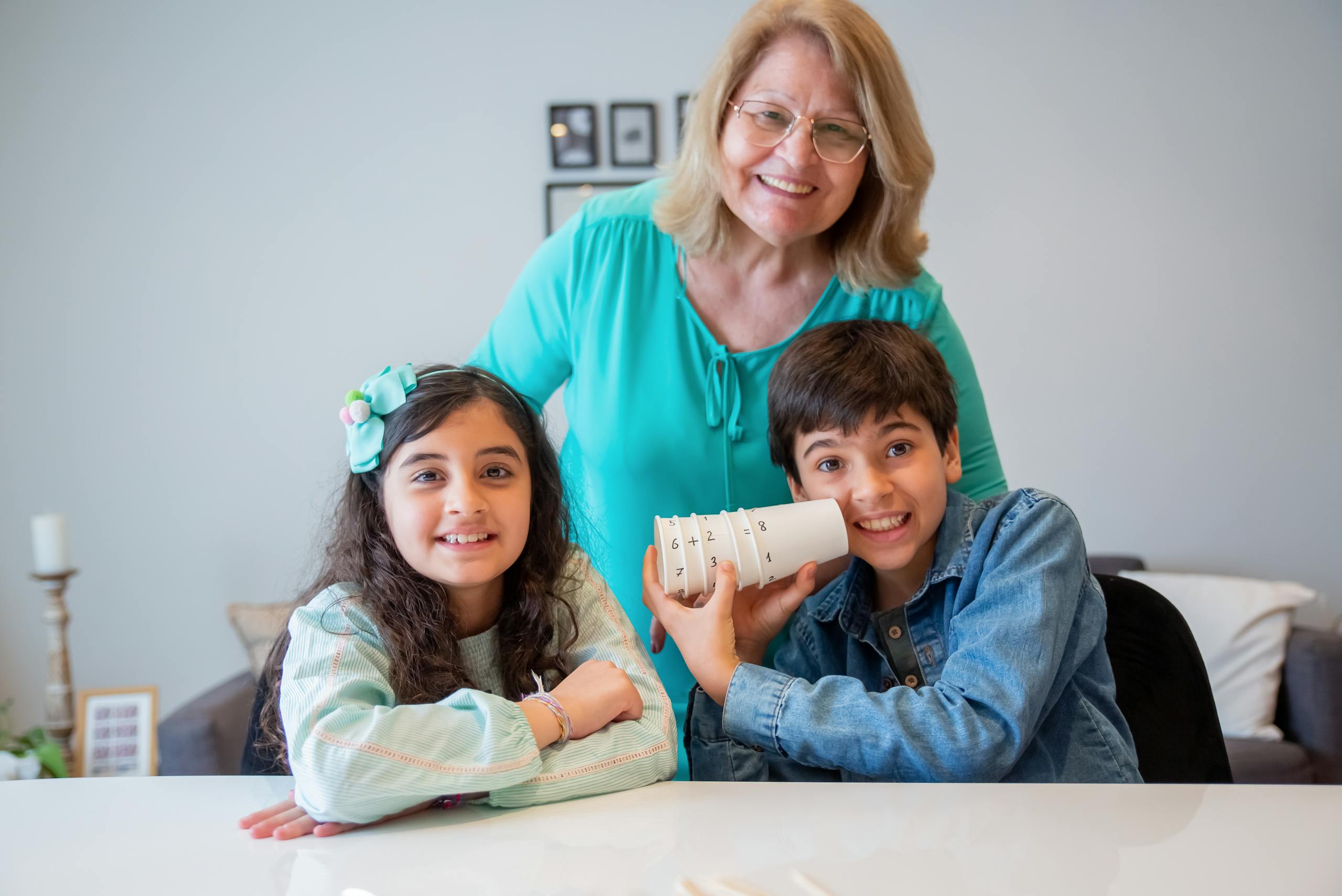 Grandmother happily posing with her grandchildren at home, showcasing family bond and love.