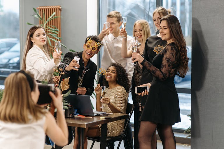 Group of diverse friends celebrating indoors with champagne and smiles, capturing the joyful moments together.