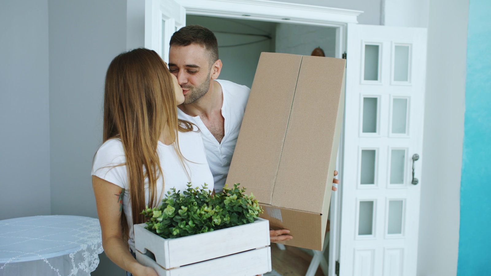 Couple carrying boxes into new home