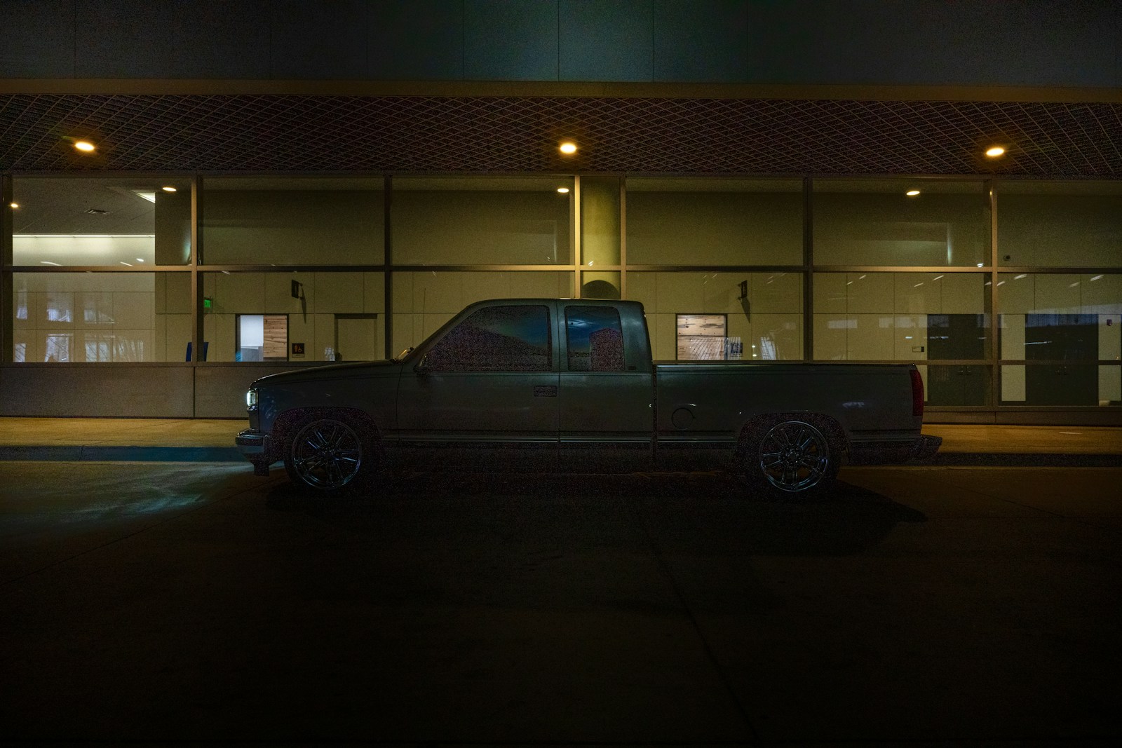 a truck parked in front of a building at night
