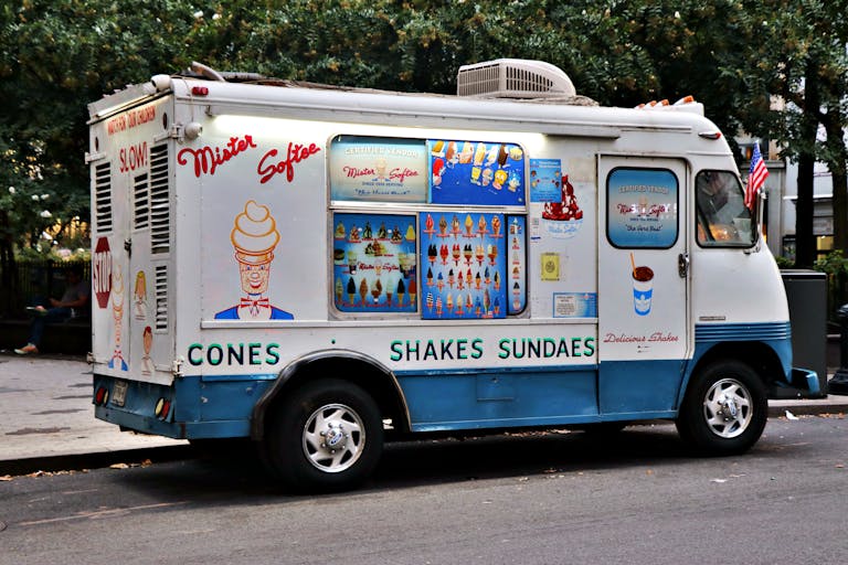 Iconic Mister Softee ice cream truck parked in a New York City street during the day.