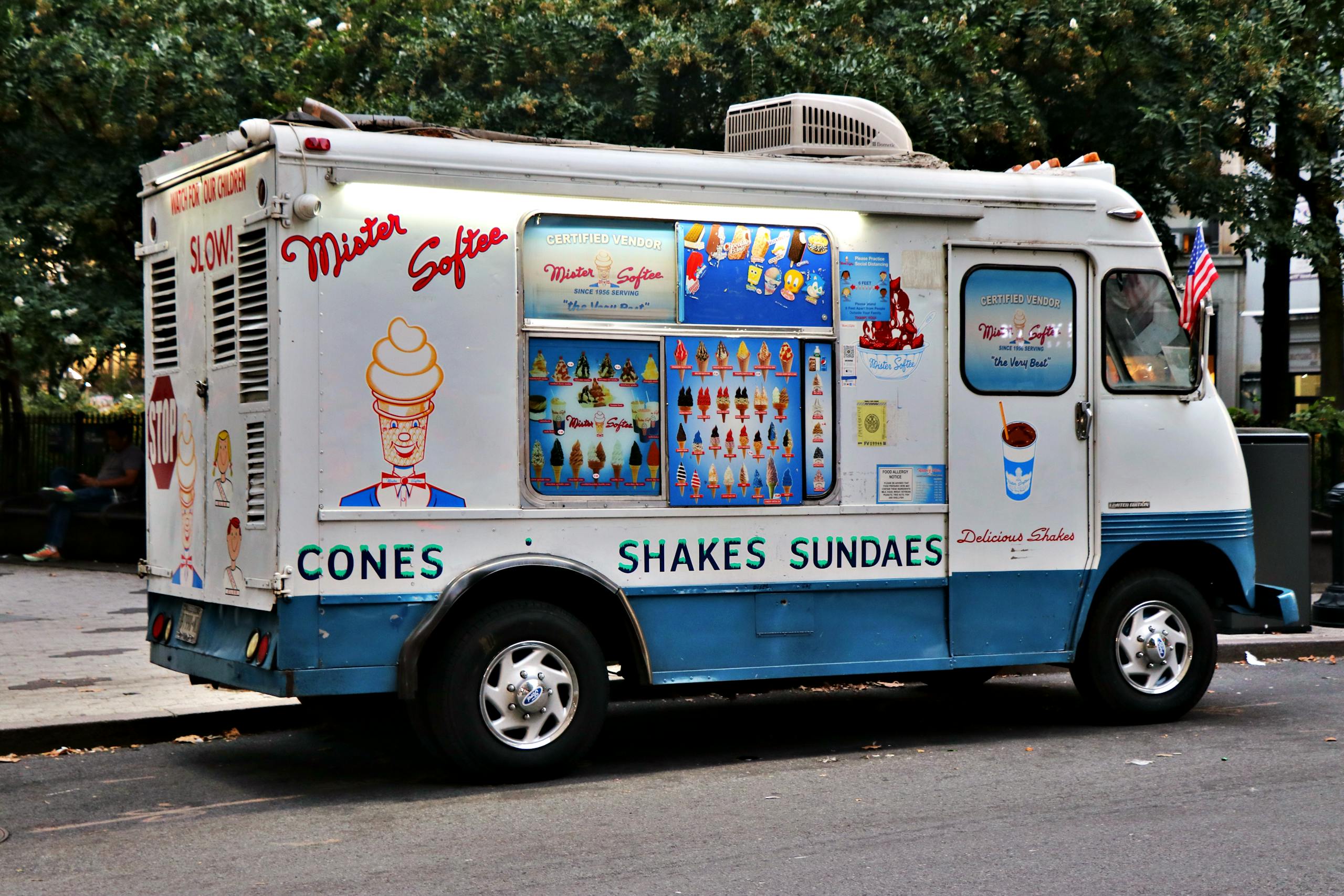 Iconic Mister Softee ice cream truck parked in a New York City street during the day.