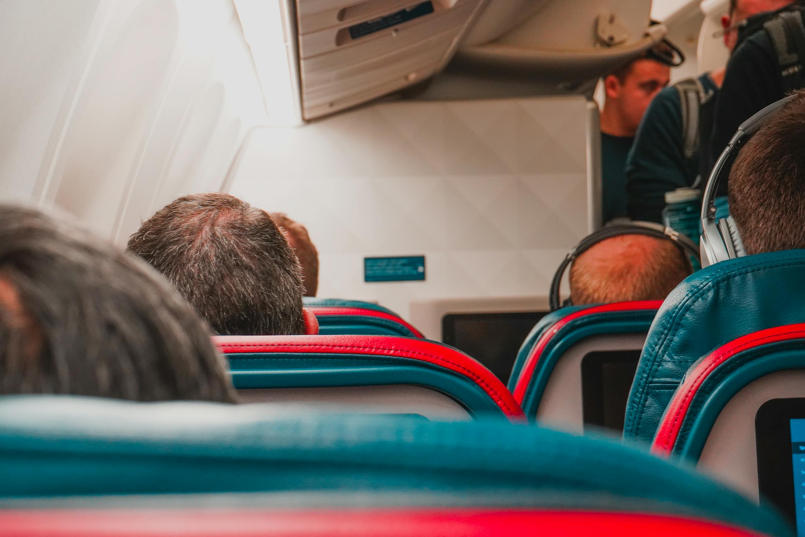 Interior view of an airplane cabin with passengers seated, focusing on seats and layout.