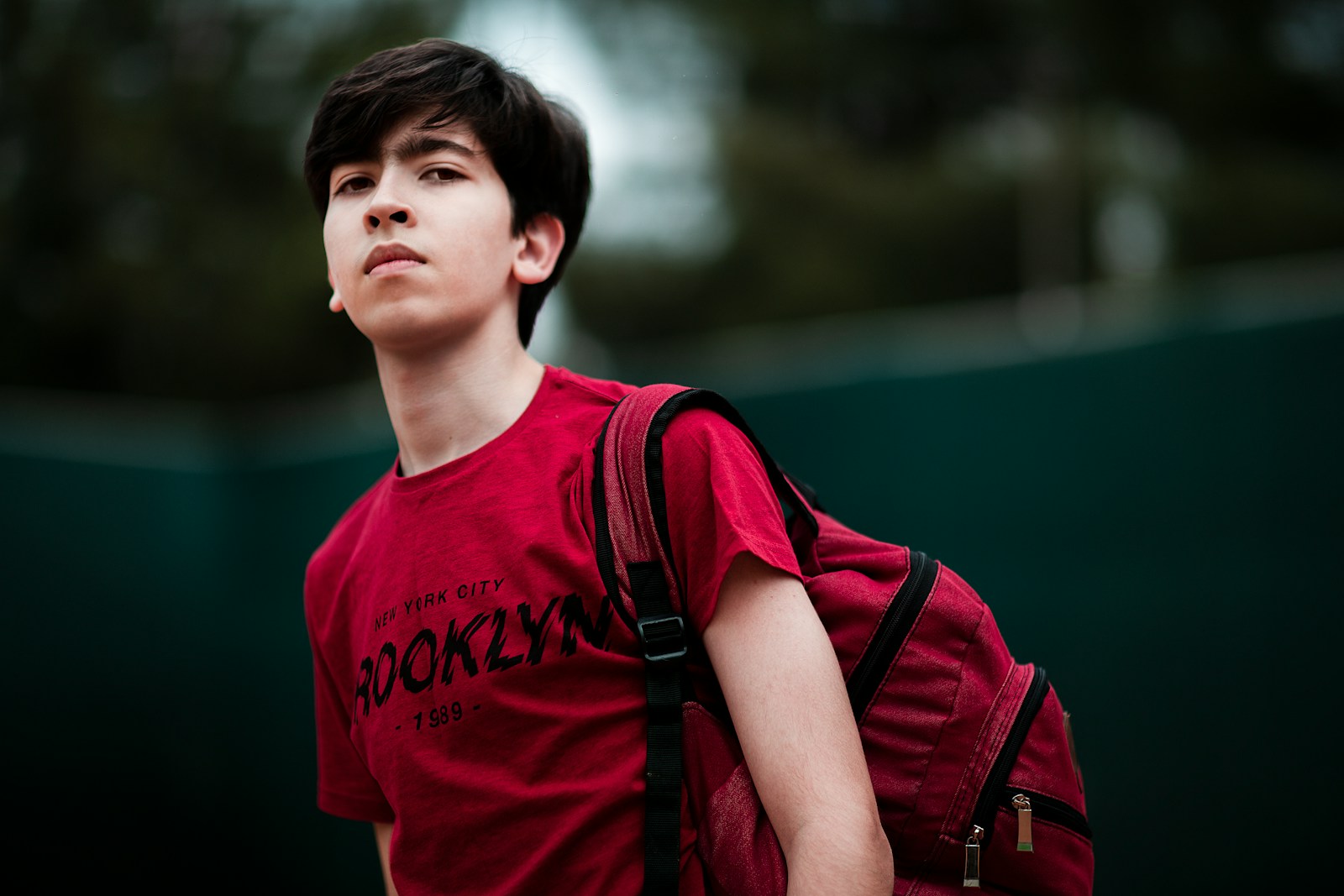 man in red crew neck t-shirt with black and red backpack