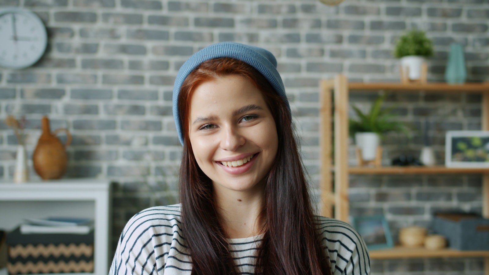 Young woman with red hair wearing a blue beanie