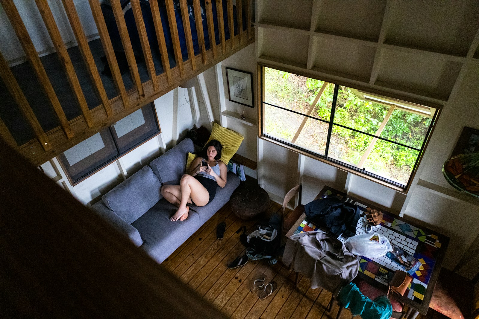 Woman relaxes on a couch inside a cozy cabin.