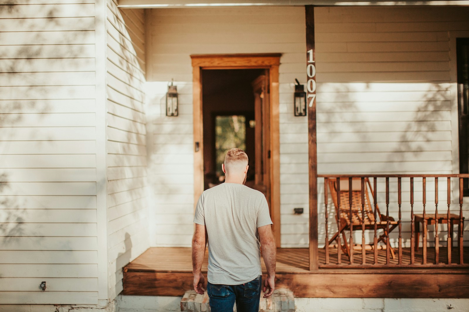 A man is standing outside of a house