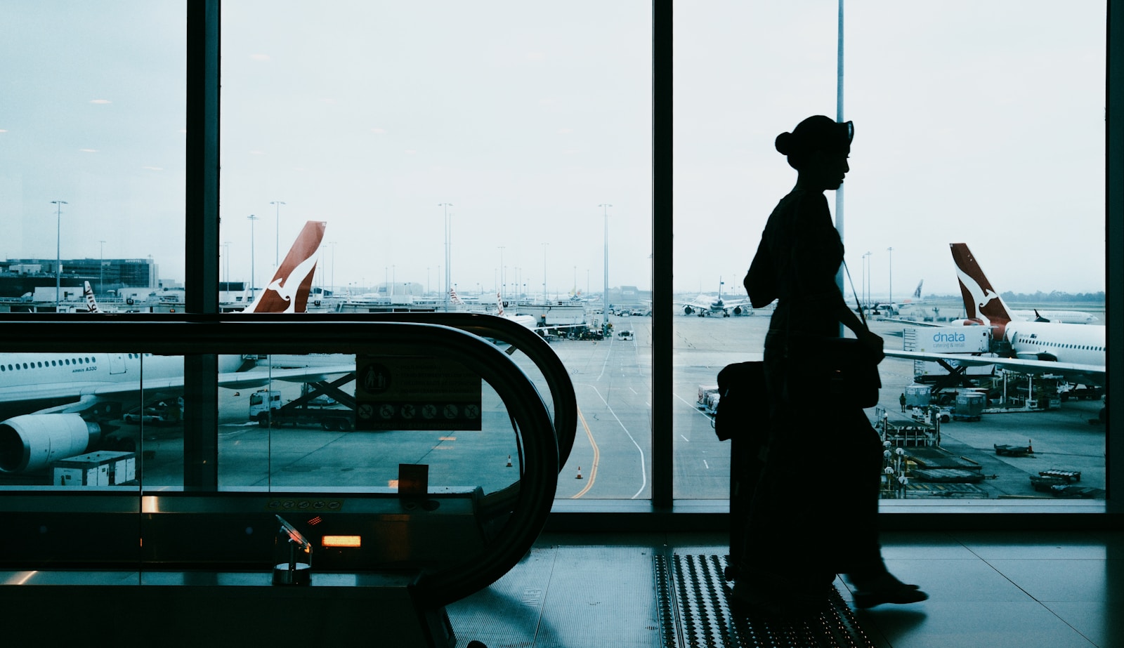 Silhouette of a woman with suitcase at airport