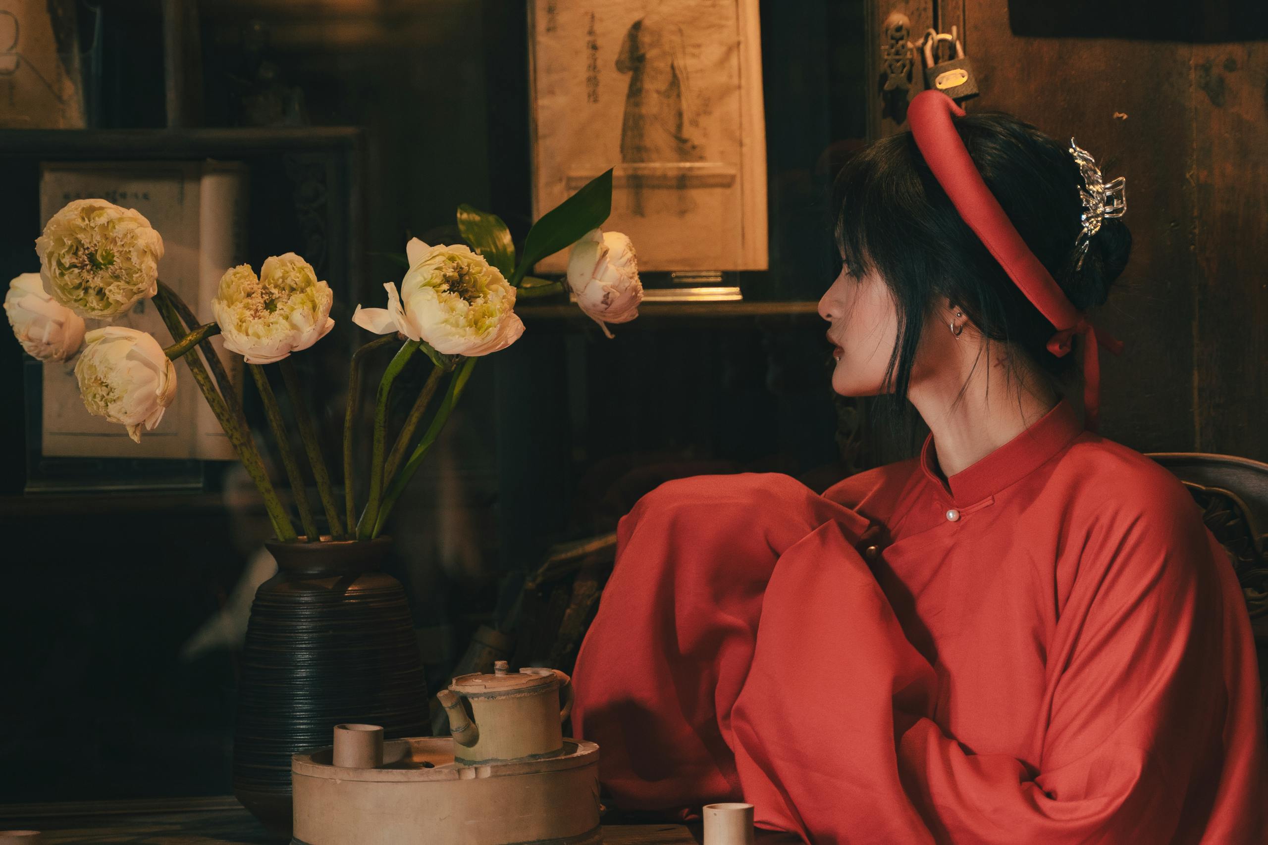 Portrait of an Asian woman in traditional attire with flowers, evoking warmth.